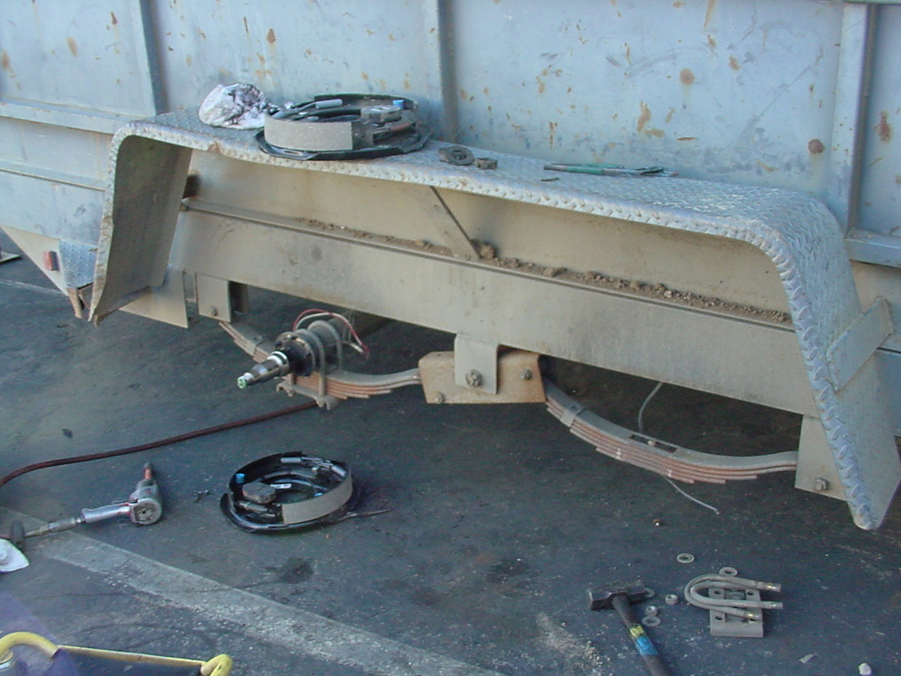 New trailer axle and brake assembly being installed by an Eckharts mechanic.