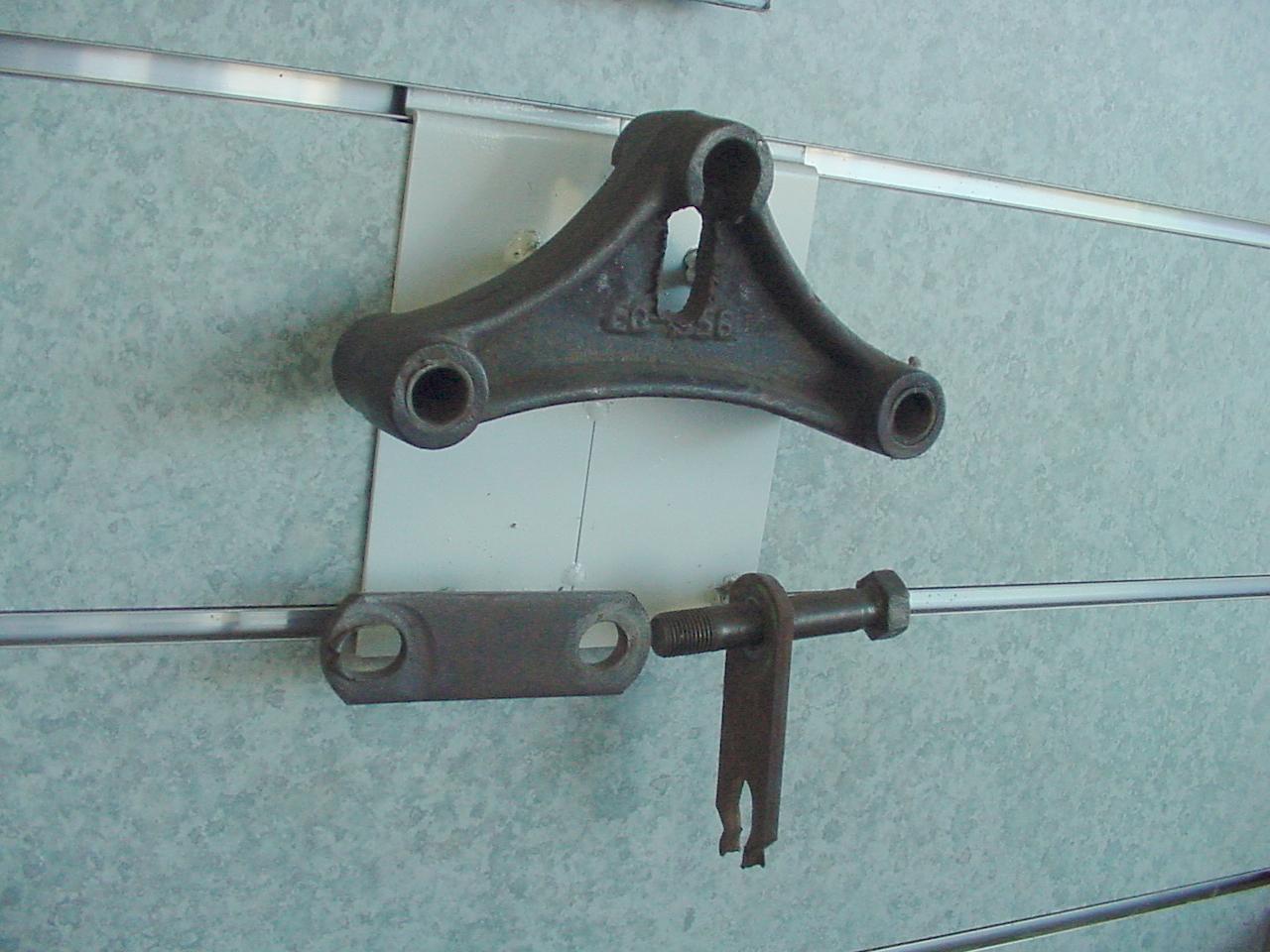 Worn trailer suspension equalizer and shackle straps requiring maintenance.